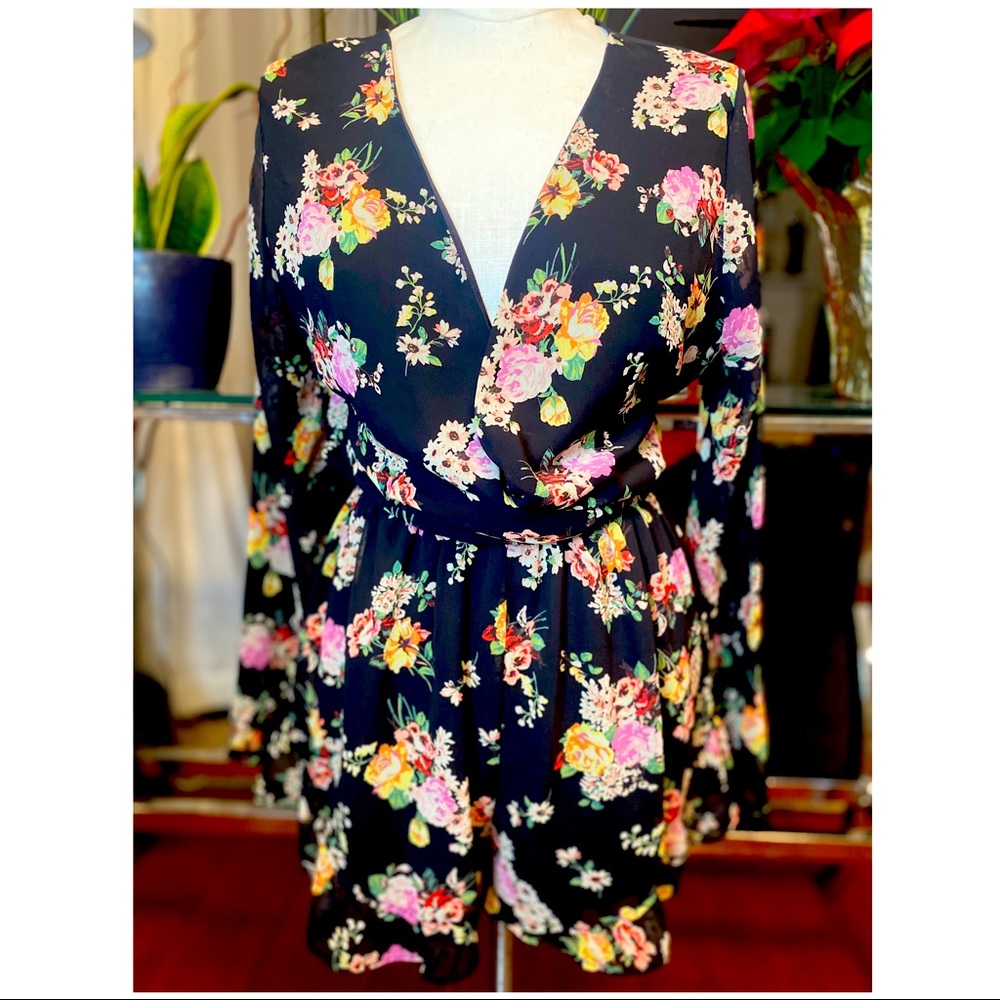 Black Floral romper shorts with ruffles at sleeves and bottom of shorts.